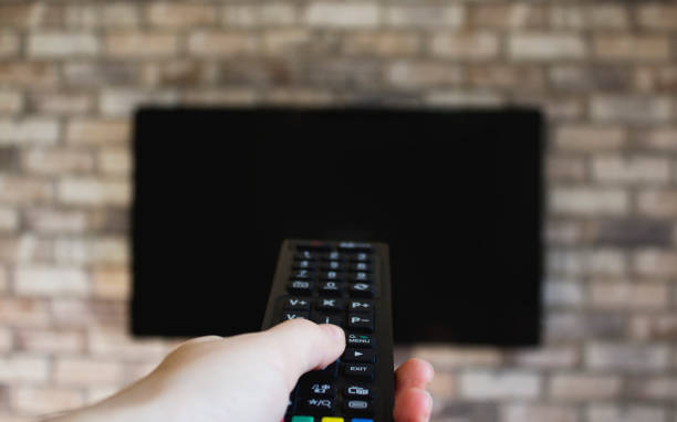 istock Woman hand with a television remote control and presses the button. 1130477363