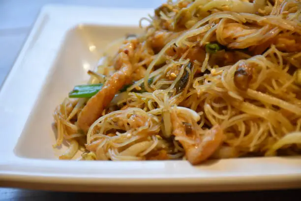 Close-up Rice noodles with Shredded Pork, stock photo - Chinese Food. Ingredients: Sprout, Pork, Rice noodles, Cong (Chinese herb: Allium fistulosum). On Wooden Table in a Chinese food Restaurant.