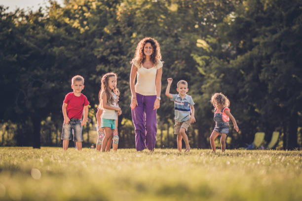 istock Group of happy children having fun while jumping in nature 1130478603