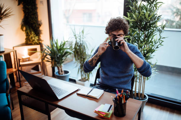 istock Male freelancer working at laptop and drinking coffee 1130480373