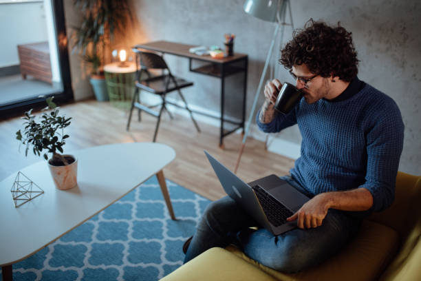 남성 프리랜서 노트북에서 일하고 커피를 마시는 - 청년만 뉴스 사진 이미지
