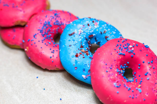 istock Delicious glazed donuts with sprinkles on light background 1130481274