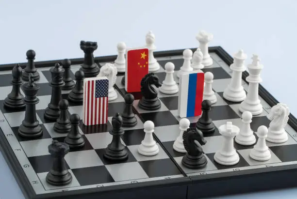 Symbols flag of Russia, United States and the China on the chessboard. The concept of political game.