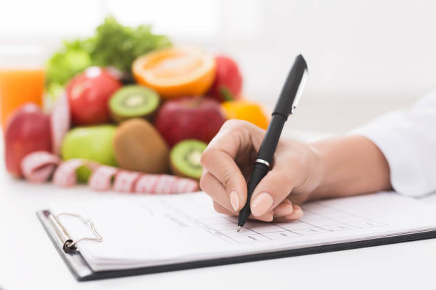 istock Nutritionist doctor writing diet plan on table 1130483131
