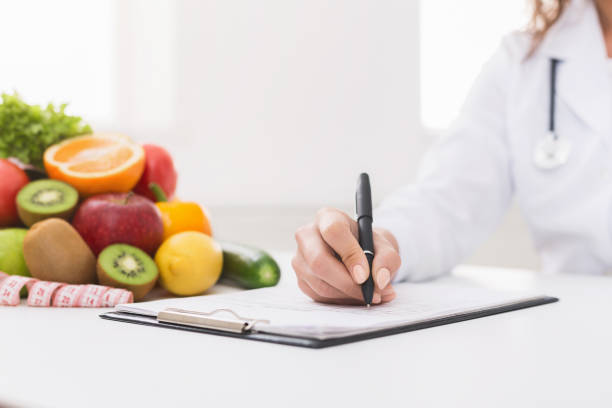 istock Doctor nutritionist writing on paperwork in office 1130483137