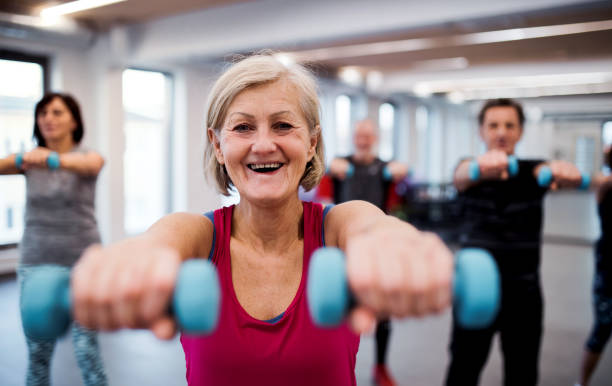 istock Group of cheerful seniors in gym doing exercise with dumbbells. 1130485498