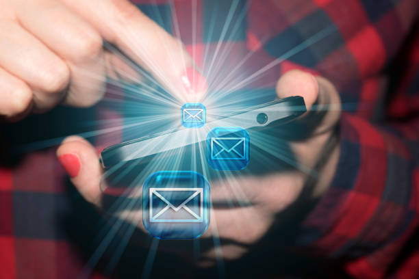 A woman sends email messages from her smartphone