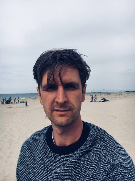 istock Portrait Of Man At Beach 1130487377