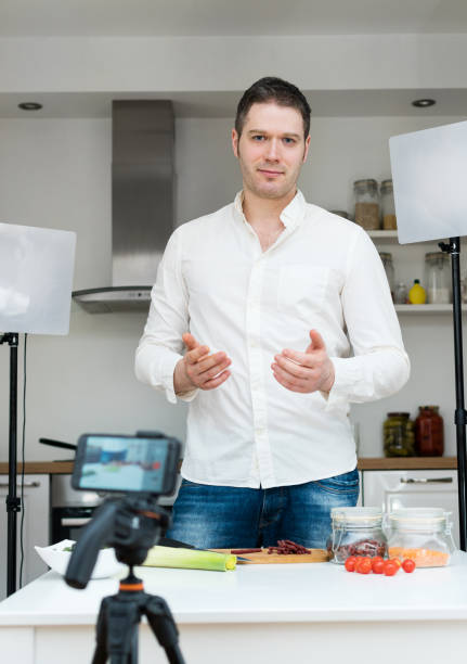 istock Man on the kitchen filming video. Vlogging concept. 1130487715