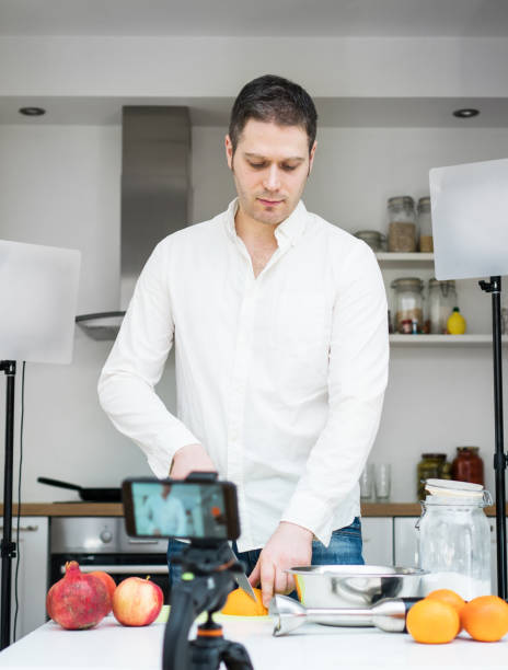 istock Man on the kitchen filming video. Vlogging concept. 1130487717