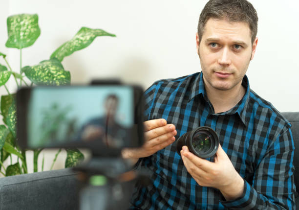 istock Handsome man making video blog about photo camera lenses. 1130487768