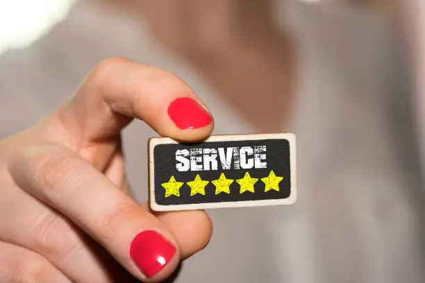 A woman and a board with rating stars for a service