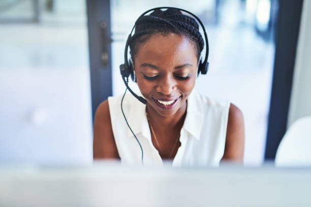 Let's get to the bottom of this query Shot of a young woman working in a call centre headset photos stock pictures, royalty-free photos & images