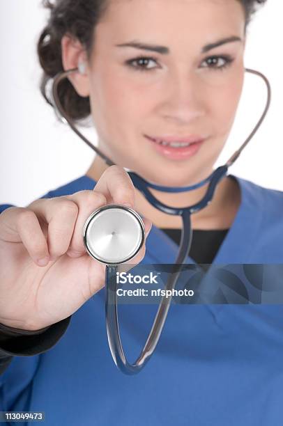 Foto de Jovem Enfermeira Vestindo Azul Esfoliações Concentrese Em Estetoscópio e mais fotos de stock de Adulto
