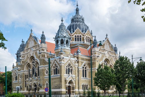 View of the building of the new Synagogue in Szeged against the blue sky with clouds.