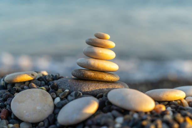 istock Stones pyramid on pebble beach symbolizing stability, zen, harmony, balance. Shallow depth of field. 1130505093