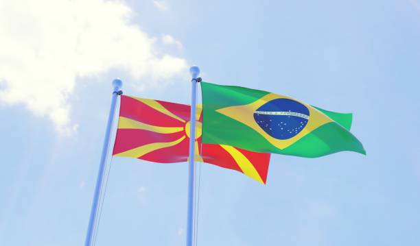 istock Macedonia and Brazil, two flags waving against blue sky 1130506047