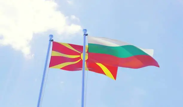 Macedonia and Bulgaria, two flags waving against blue sky. 3d image