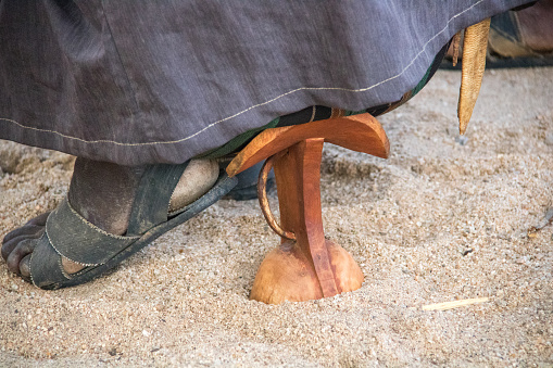 A Hamer man uses a traditional wooden seat in a village near Turmi.