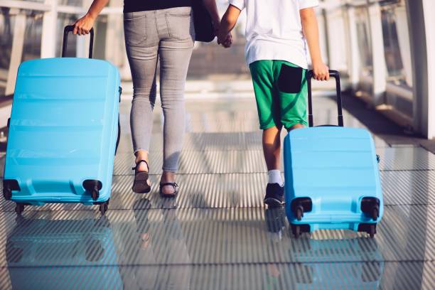 istock Woman and child with blue baggage suitcase on train station 1130507589