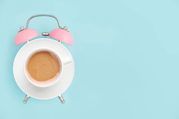 istock Pink alarm clock and coffee cup on blue background. Breakfast time concept. Minimal style 1130511474