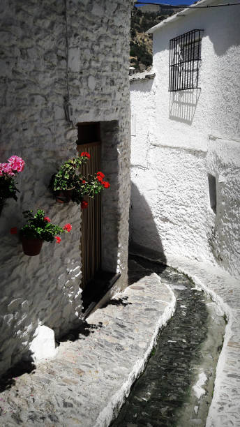 Down street in old spanish town Granada, Spain. april 2017. View of the descent of water and the white houses in a street any of a Spanish town paisaje urbano stock pictures, royalty-free photos & images