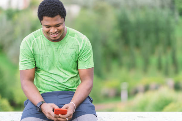 istock Young man using smart phone in public park 1130513379