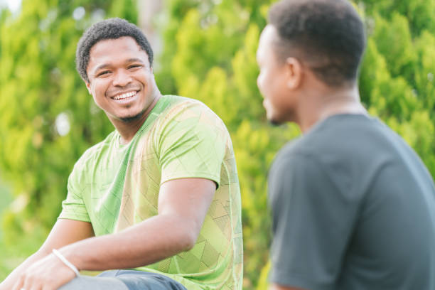 istock Two young male friends having conversation in public park 1130513448