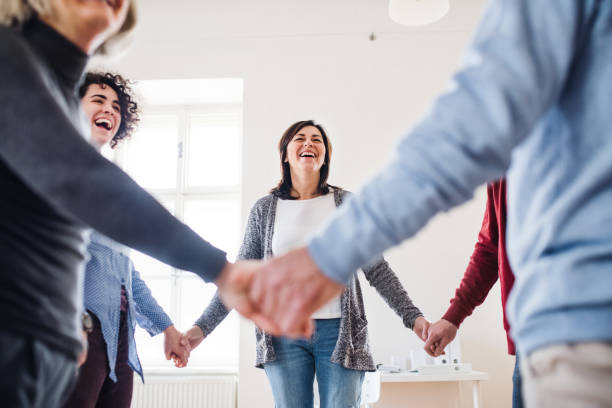 istock Midsection of people standing in a circle and holding hands during group therapy. 1130513640