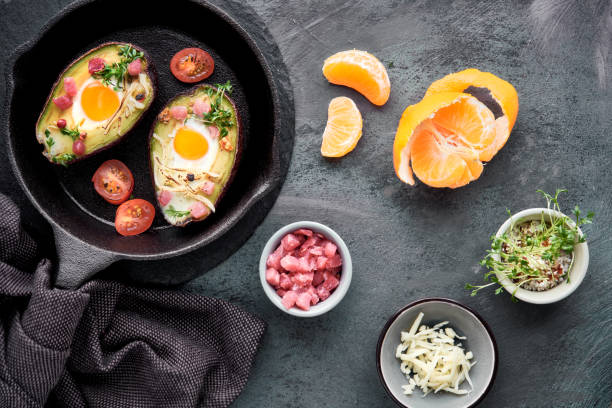 istock Keto diet dish: Avocado boats with ham cubes, quail eggs, cheese, ingredients around 1130514311