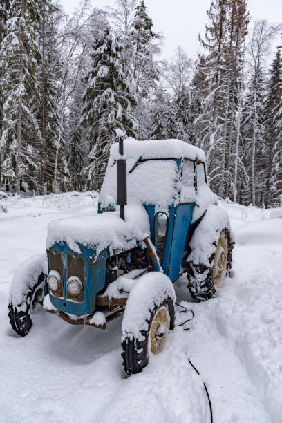 istock old blue tractor standing covered in snow 1130514769