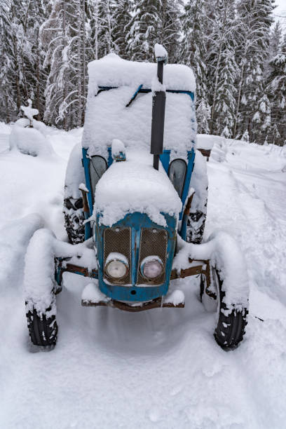 istock old blue tractor standing covered in snow 1130514771