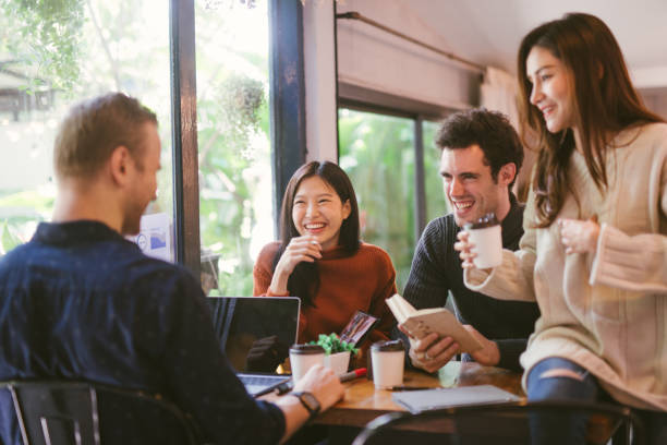 people talking happy in cafe Group of friends chatting and using laptop in cafe at the coffee shop cafe in university talking and laughing together. nanyang coffee photos stock pictures, royalty-free photos & images