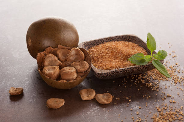 Luo Han Guo aka Monk fruit natural herbal remedy and sugar on brown background. Powerful healthy sweetener.
