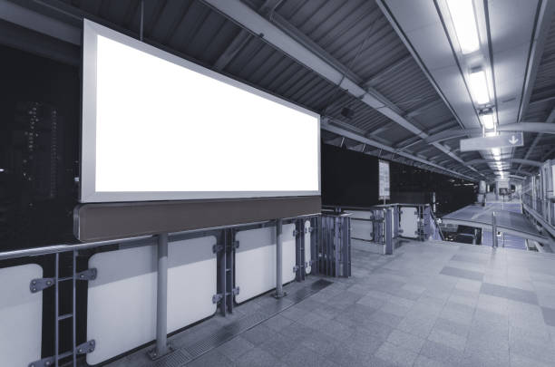 istock large blank advertise billboard white LED screen horizontal for design banner announcement exit way at outdoor public sky train platform station. 1130521416