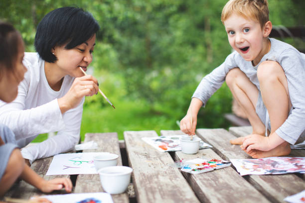 istock Mother painting with her children 1130525898
