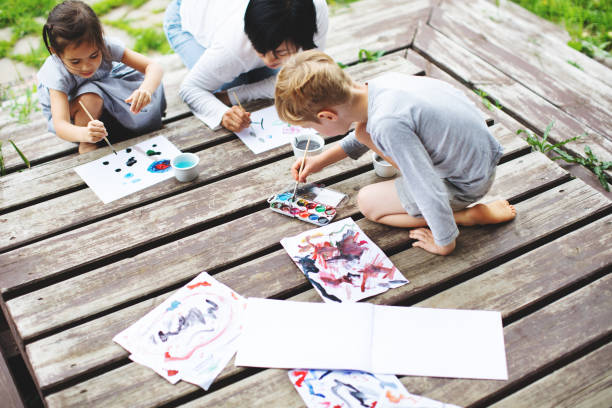 istock Mother painting with her children 1130525899