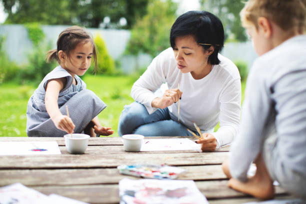 istock Mother painting with her children 1130525971