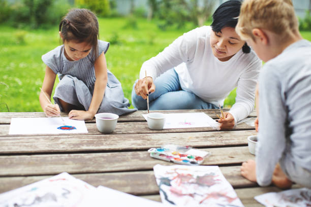 istock Mother painting with her children 1130525984