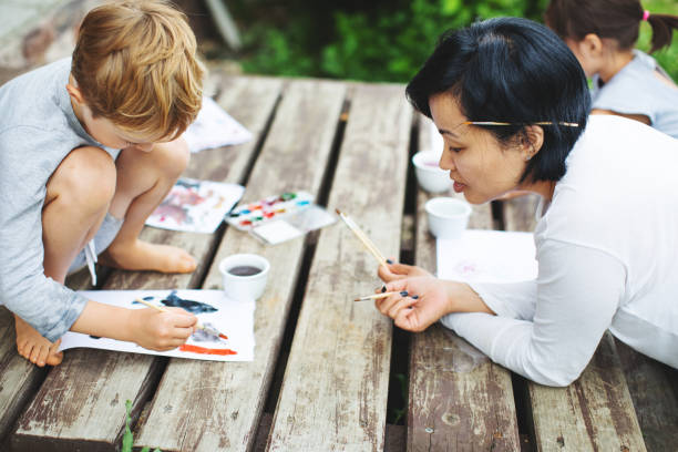 istock Mother painting with her children 1130525985