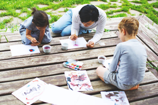 istock Mother painting with her children 1130525996
