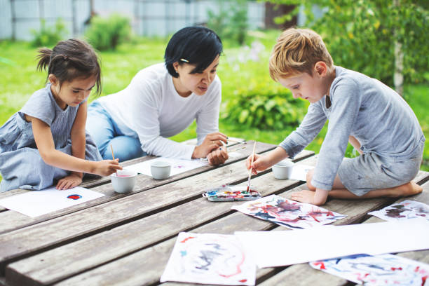 istock Mother painting with her children 1130526006