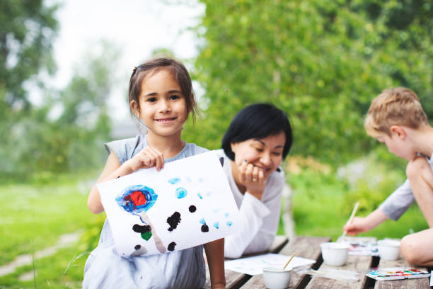istock Mother painting with her children 1130526131