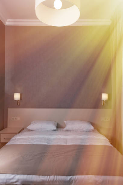 ホテルの部屋でダブルベッドにはスタイリッシュなインテリア。ランプのかさが付いているランプ。 - double bed headboard hotel room design ストックフォトと画像