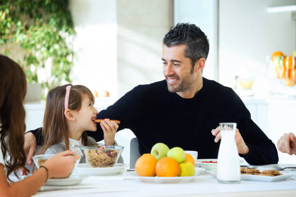 istock Happy family eating breakfast and having fun in kitchen table at home. 1130527901