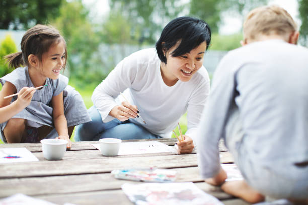 istock Mother painting with her children 1130528365
