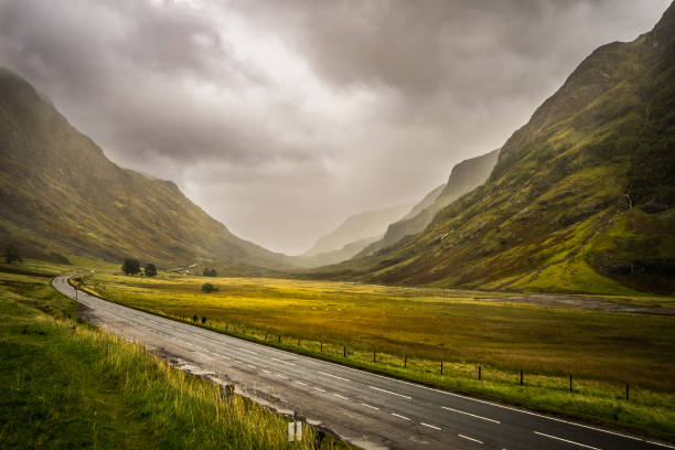 Street through a dusty valley Dust in Scottish Highlands over a street through Glen Coe valley glencoe scotland photos stock pictures, royalty-free photos & images