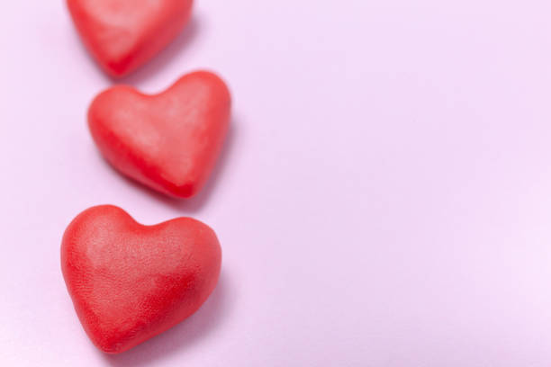 close up hearth shape molding clay on pink background