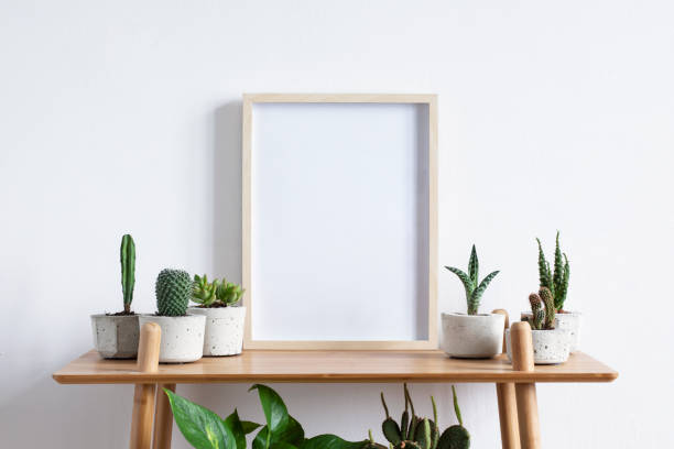 Photo of Stylish room interior with mock up photo frame on the brown bamboo shelf with beautiful plants in differents hipster and design pots. White walls. Modern and floral concept of shelfs.