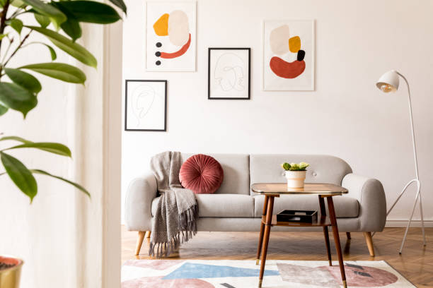 elegant and vintage apartment interior with classic wooden furniture, grey sofa, retro coffee table, lamp and mock up posters gallery. brwon parquet, stylish carpet and plants. bright space. - interior designer imagens e fotografias de stock